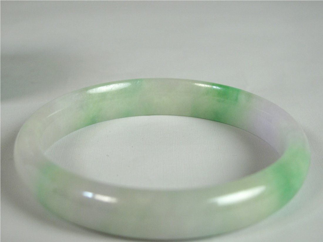 A Chinese Jadeite Bangle Bracelet: Chinese jadeite small bangle bracelet, the translucent matrix with lavender and apple-green inclusions. D: 7 cm