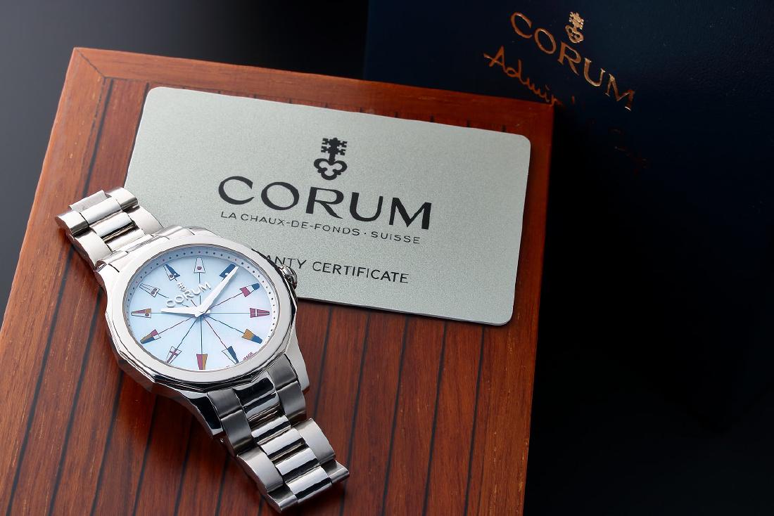 Steel Corum Admiral`s Cup Legend 38 Watch: Stainless steel Corum Admiral`s Cup Legend 38 wristwatch, ref #020.201.20/V200 PN22. White mother of pearl (MOP) Corum dial with painted nautical flags hour markers. Swiss made, quartz movement. Comes