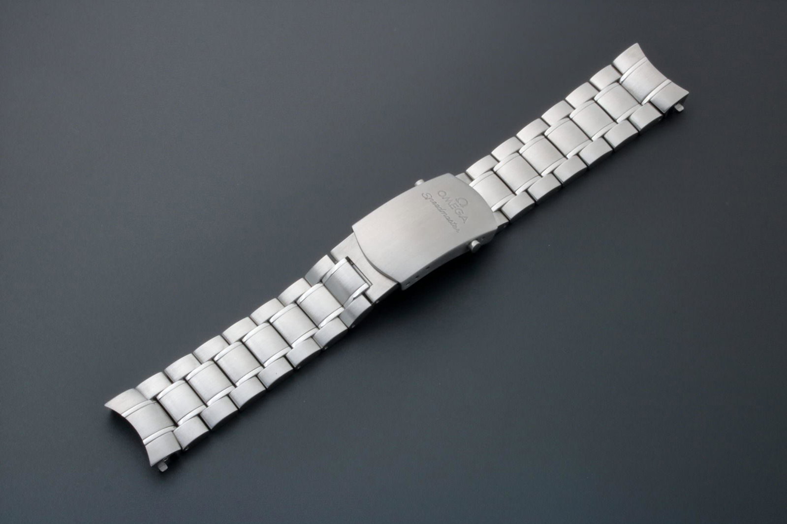 Omega Speedmaster 19MM Watch Bracelet 1564/975: Stainless steel 19mm Omega Speedmaster watch bracelet. Swiss made. Push button release buckle stamped OMEGA 1564/975 STAINLESS STEEL SWISS MADE. Matching solid end pieces marked 975. Comes as