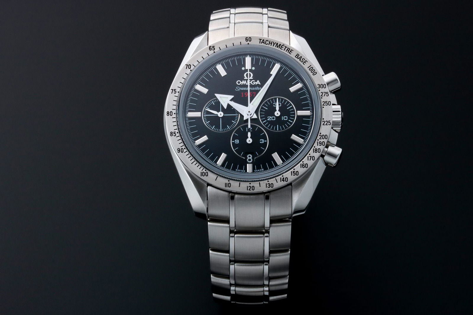 Omega Speedmaster 1957 Broad Arrow Watch: Stainless steel men's Omega Speedmaster 1957 Broad Arrow Co-Axial chronograph wristwatch, ref #321.10.42.50.01.001. Black Omega dial with 1957 in red, 3 registers, applied stick hour markers, and br