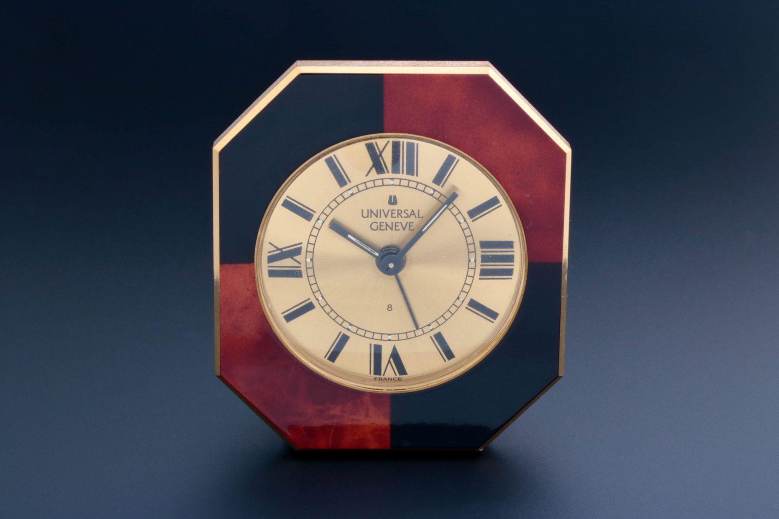 Universal Geneve Travel Table Alarm Clock Vintage: Vintage Universal Geneve travel table clock with alarm. Circa 1980's. Champagne Universal Geneve dial with painted black Roman numerals. Luminescent hour marker dots and hands. Dial marked wit