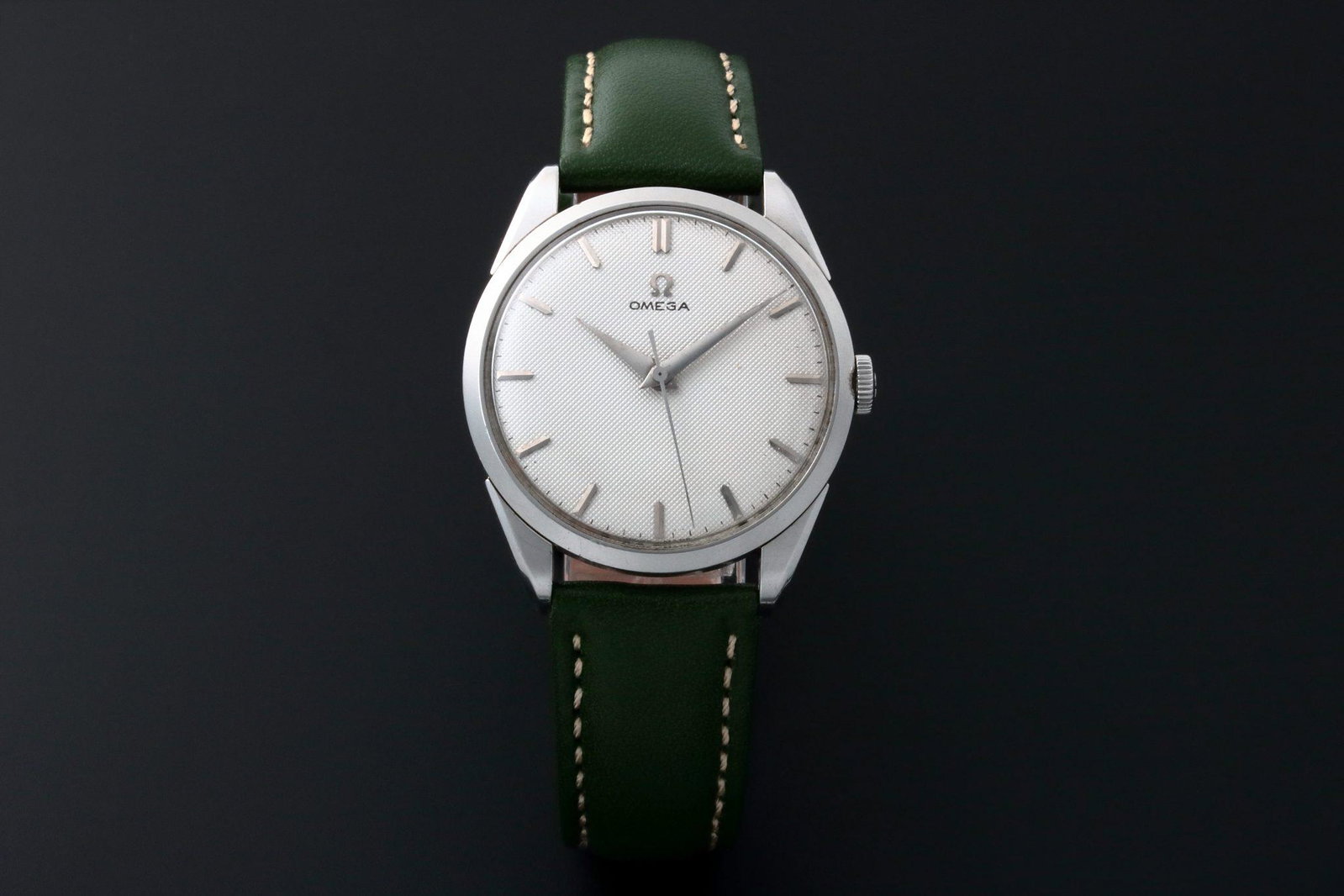 Omega with Honeycomb Dial Vintage Watch: Vintage gents stainless steel Omega wristwatch. Omega silver texture dial with applied bar hour markers. Stainless steel bezel. Stainless steel Omega crown. Swiss made, mechanical manual wind 