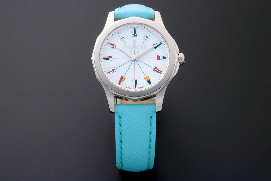 Corum 01.0133 Admiral's Cup Mother of Pearl Watch: Stainless steel Corum Admiral's Cup wristwatch, ref #01.0133/B. White Corum mother of pearl dial with nautical flags hour markers. Swiss made, quartz movement. Comes on a brand new Tokki Proje