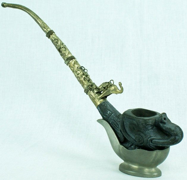 Elephant Pipe with Dunhill Metal Stand: Figural elephant pipe with Dunhill metal stand holder. Hammered metal stem on pipe. Approximately 10 - 1/4" (L) x 6 - 1/2" (H).