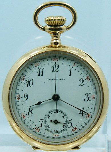18k Yellow Gold Tiffany & Co One Button Chronograph: Rare 18k yellow gold Tiffany & Co one button chronograph pocket watch. White enamel dial with black painted Arabic numerals, red five minute outer track, and subsidiary seconds. The case back has a mo