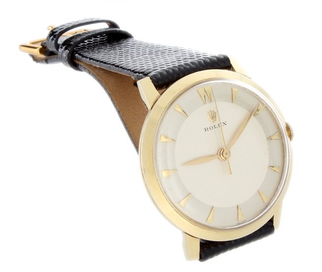 Vintage 14k Yellow Gold Mens Rolex Dress Watch: Vintage 14k yellow gold gents Rolex dress wristwatch, Rolex pie pan style dial with yellow gold arrowhead markers, Swiss made, manual wind movement, case back is engraved, generic black strap with gen