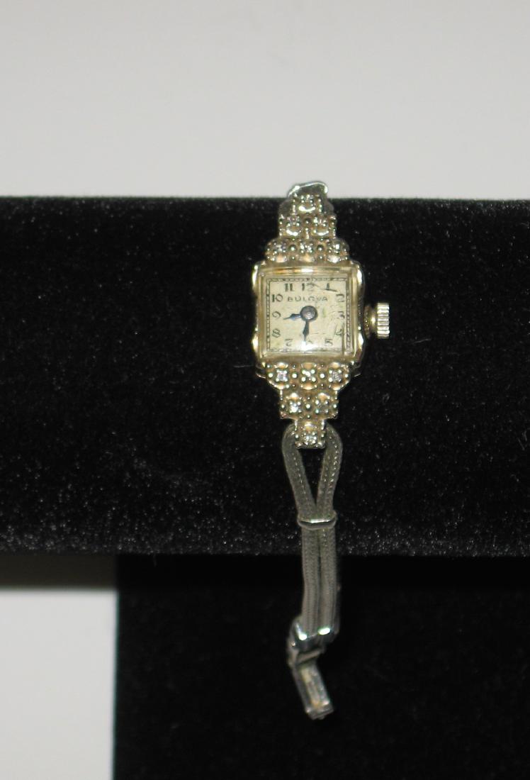 Ladies 14K case Bulova watch,: Bulova watch case in 14K gold with diamonds fitted with a gold filled band. Condition: not working.