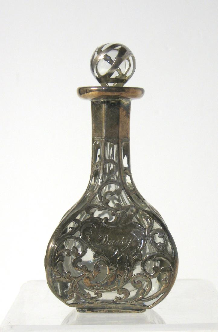 Silver overlay perfume bottle,: Silver overlay bottle with scrolling and central medallion with inscribed Daisy 97, marked solid silver 2666 pat. Jan 5 86. 4 1/2" ht. Condition: good with no chips cracks or repairs.