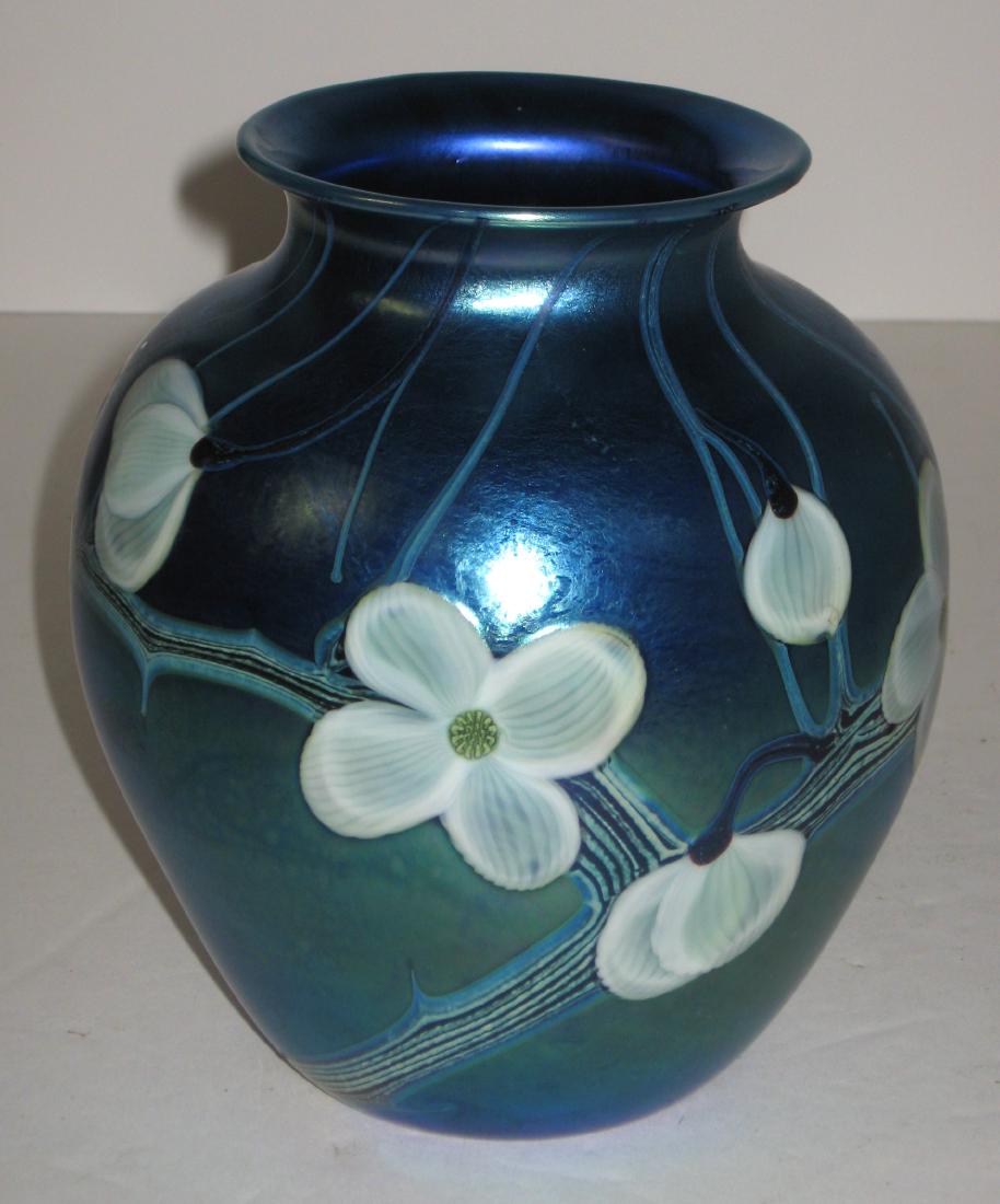 Orient and Flume art glass vase,: Ovoid form in iridescent blue decorated with White dogwood blossoms on blue branches, signed Orient and Flume, 7' ht. Condition: Good with no chips, cracks, or repairs.
