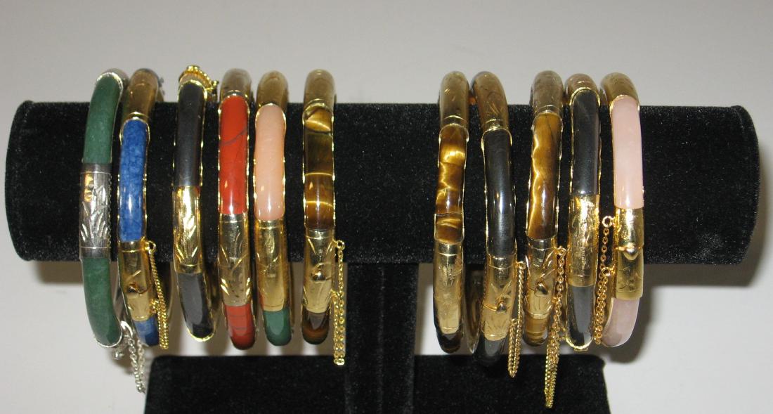 Group of 11 gold tone and colored bangles, (1 of 3)