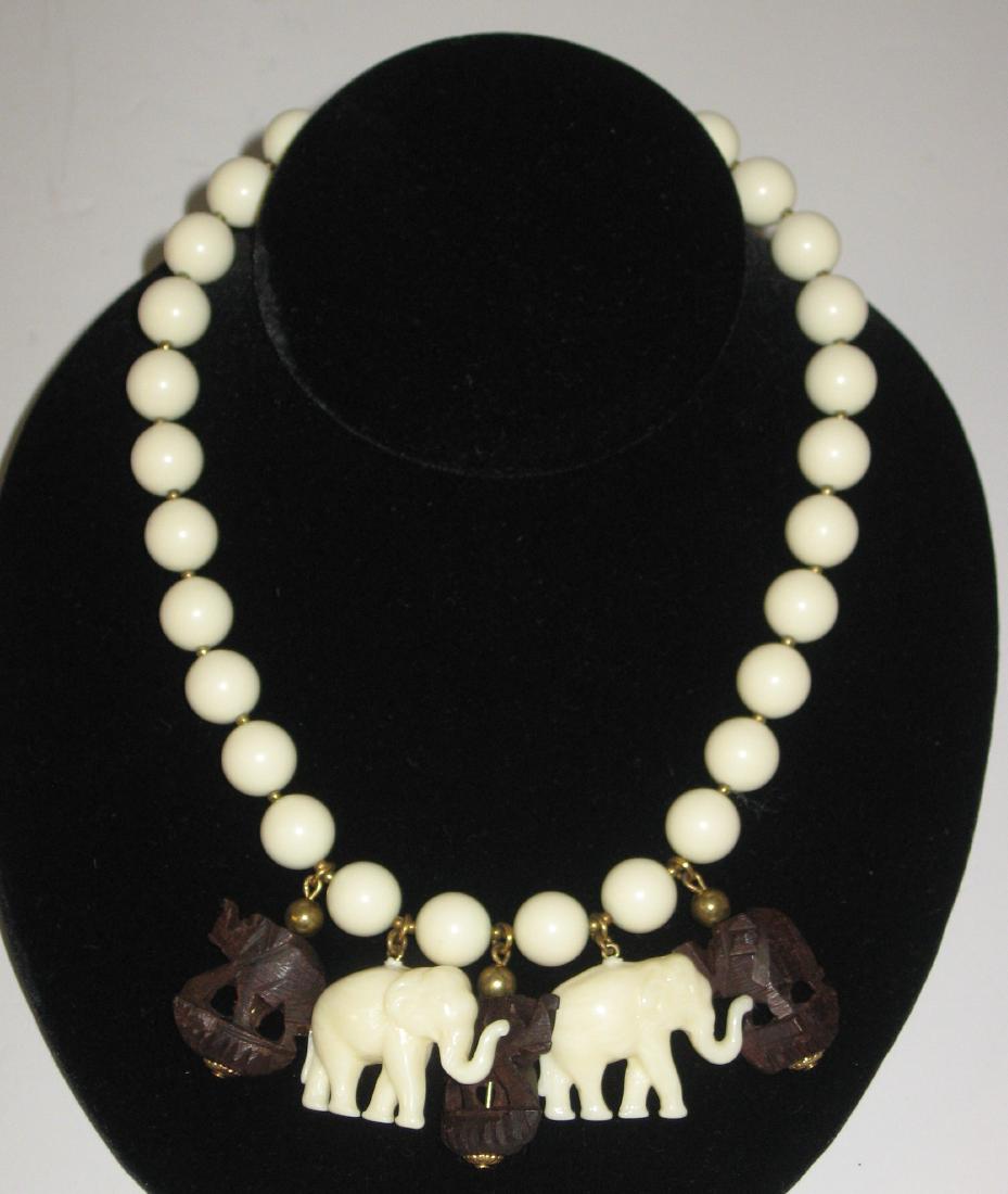 Miriam Haskell celluloid necklace,: String of celluloid beads adorned with teak wood and celluloid elephants, marked Miriam Haskell, 14" long. Condition: good with no issues.