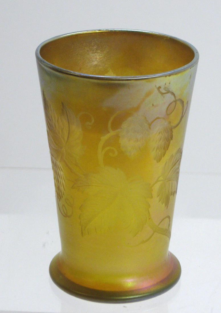 Tiffany intaglio cut gold Favrile tumbler,: Footed cylindrical form in bright gold Favrile glass decorated with a bands of raspberries and leaves, signed L C. Tiffany Favrile, 4" ht. Condition: excellent color with no defects found.