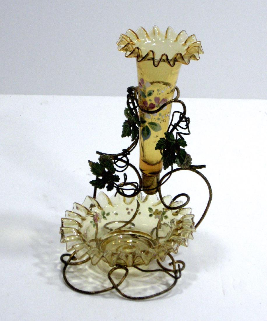 Continental amber glass epergne,: Ruffled rim trinket tray and trumpet bud vase set in a leaf embossed metal frame and decorated with colorful flowers, 7' ht. Condition: good with no chips cracks or repairs.