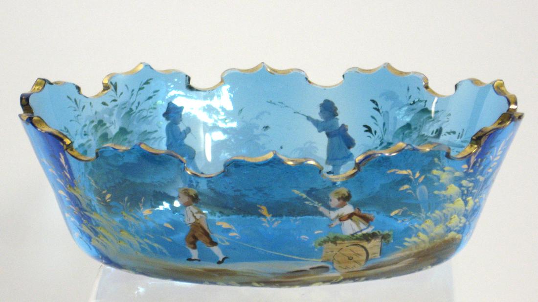 Lobmeyr Prussian blue glass bowl: Scalloped rim bowl decorated with two children fishing with the reverse with two children and a wagon accented with a gold crown rim, 8" long. Condition: good with no defects found.