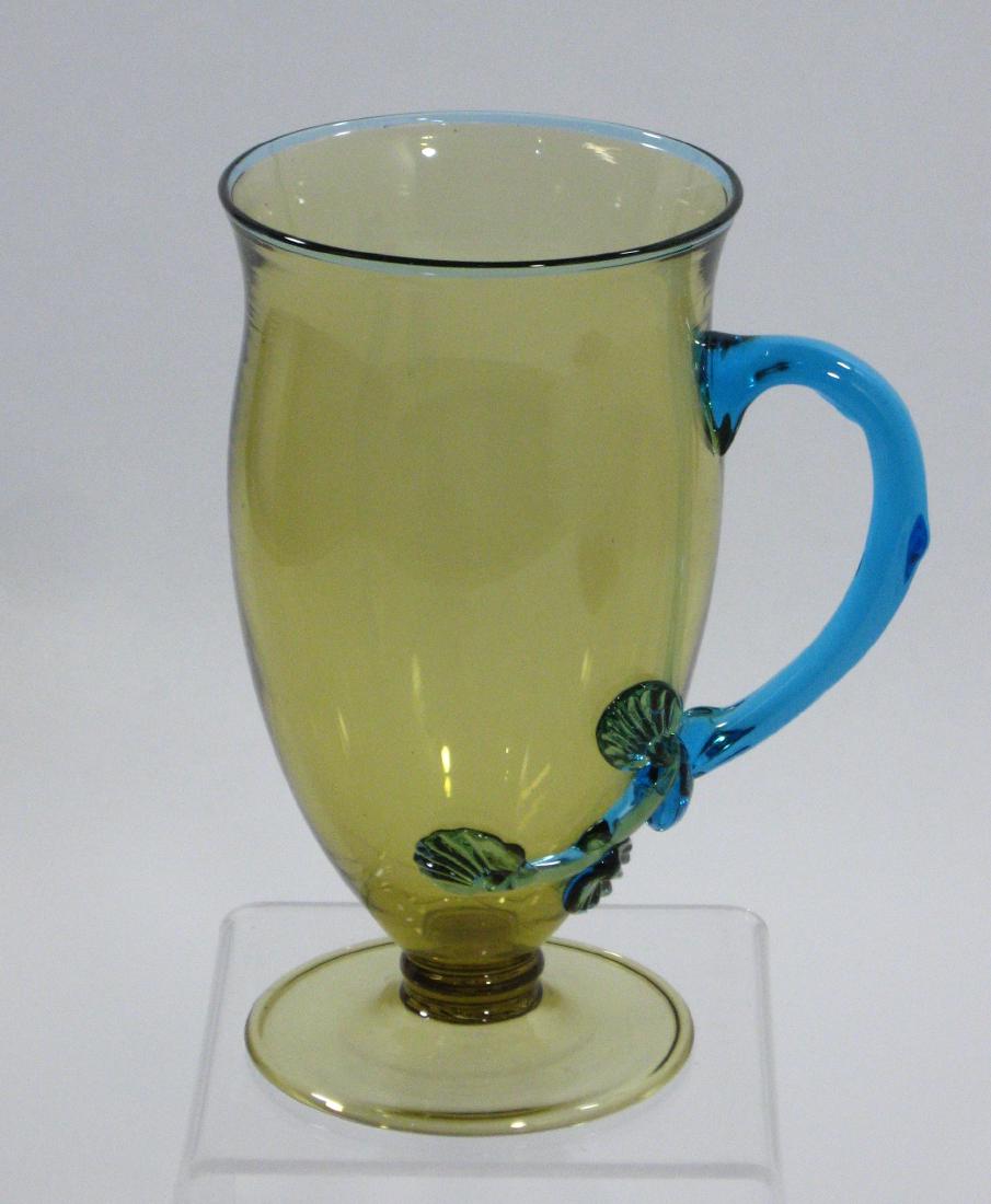 Steuben Mat-zu-no-kee handle cup,: Amber mug shape #3329 with Celeste blue handle extending to a Mat-zu-no-kee dŽcor, 6" ht. Condition: good with no defects found.