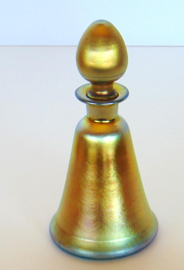 Steuben Gold Aurene perfume: Conical form in iridescent gold glass adorned with a fat tear drop stopper, signed Aurene 1818, 5 1/2" ht. Condition: good with one scratch on the stopper.