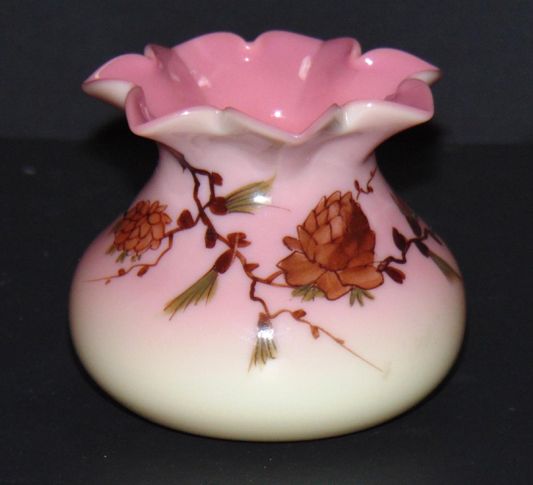 Webb glossy finish Burmese vase: Ovoid form with a seven pointed rim adorned with pine cones and branches, marked Thomas Webb and Sons, 3" ht. Condition: good with no defects found.