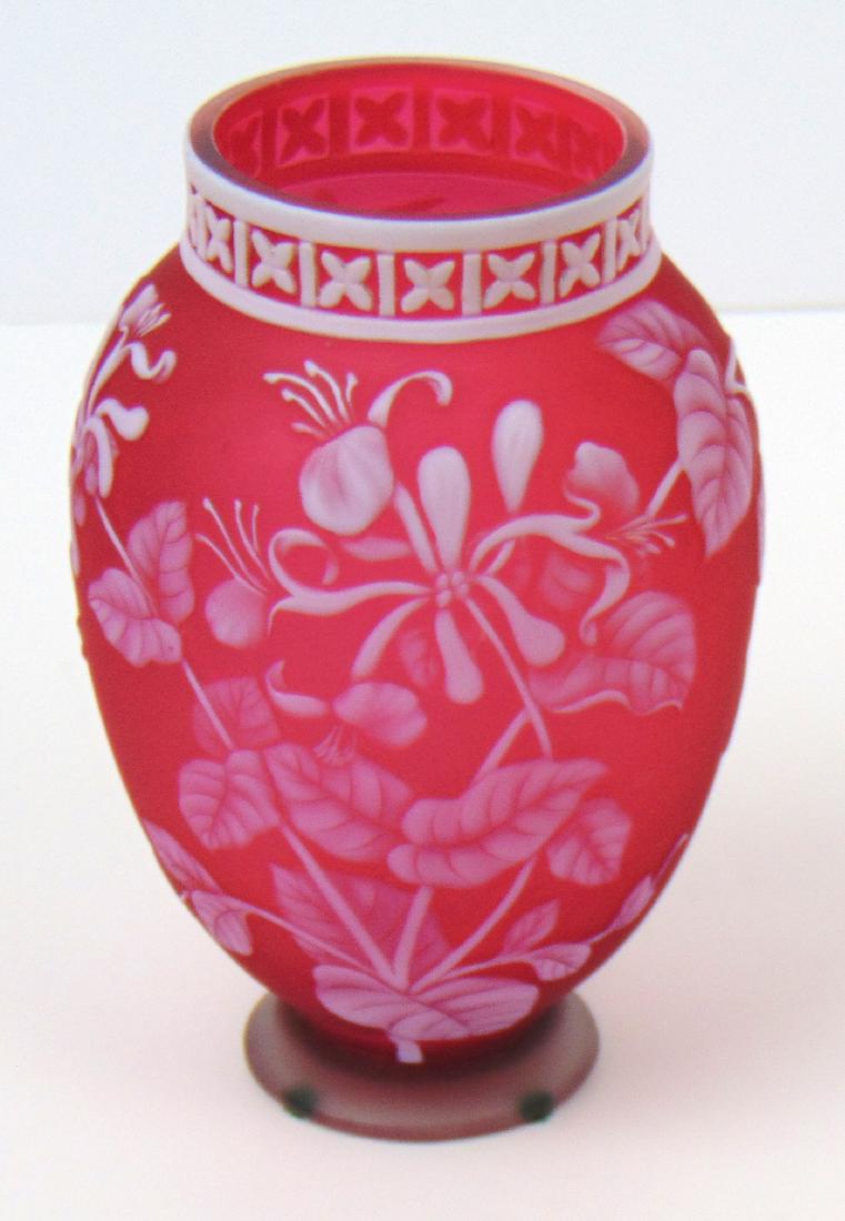 Webb Cameo Honeysuckle Glass Vase: Footed red glass vase decorated with a honeysuckle vine, adorned with an X carved rim, signed Thomas Webb and Son's, 6" ht. Condition: good with no defects found