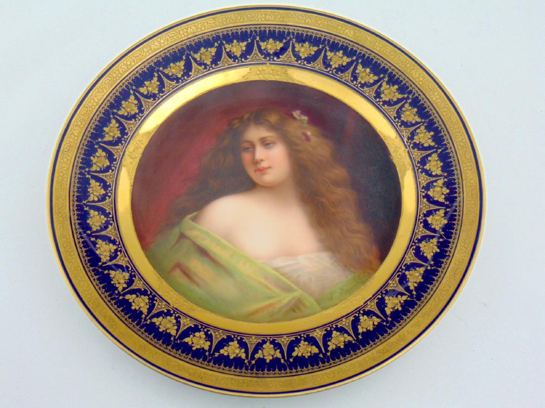 Royal Vienna porcelain plate: Pictorial plate of a young woman titled Lassitude" after a painting by Angelo Asti. The medallion is framed with cobalt and gold scrolling, marked with the Royal Vienna beehive back stamp, 9 1/2" wide