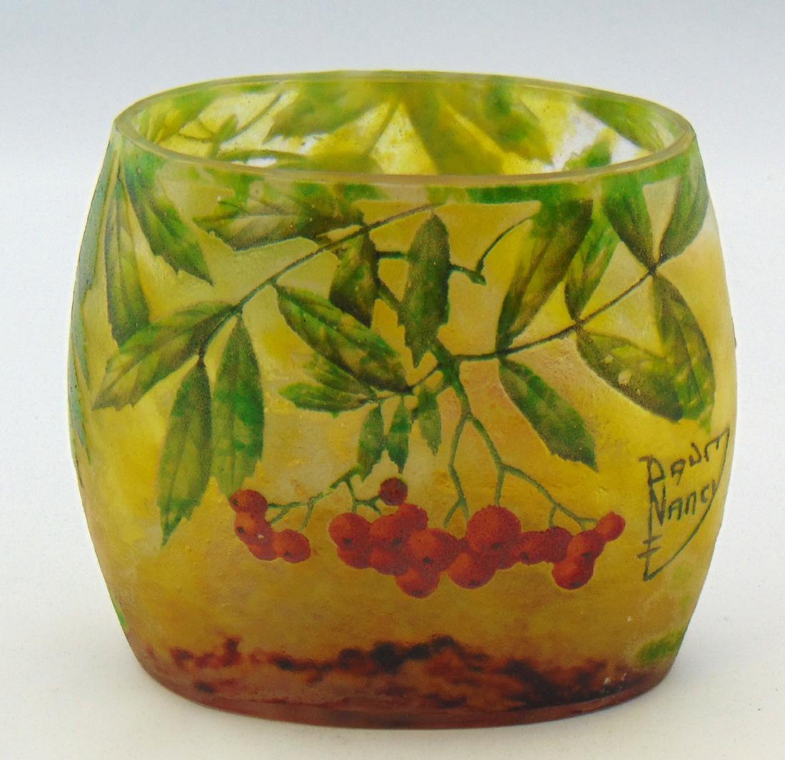 Daum Nancy French cameo glass vase,: Pillow form in mottled crimson and yellow glass decorated with a green leafy branch of berries on front and back, signed in cameo Daum Nancy, 5 1/2" wide. Condition: good with no defects found.