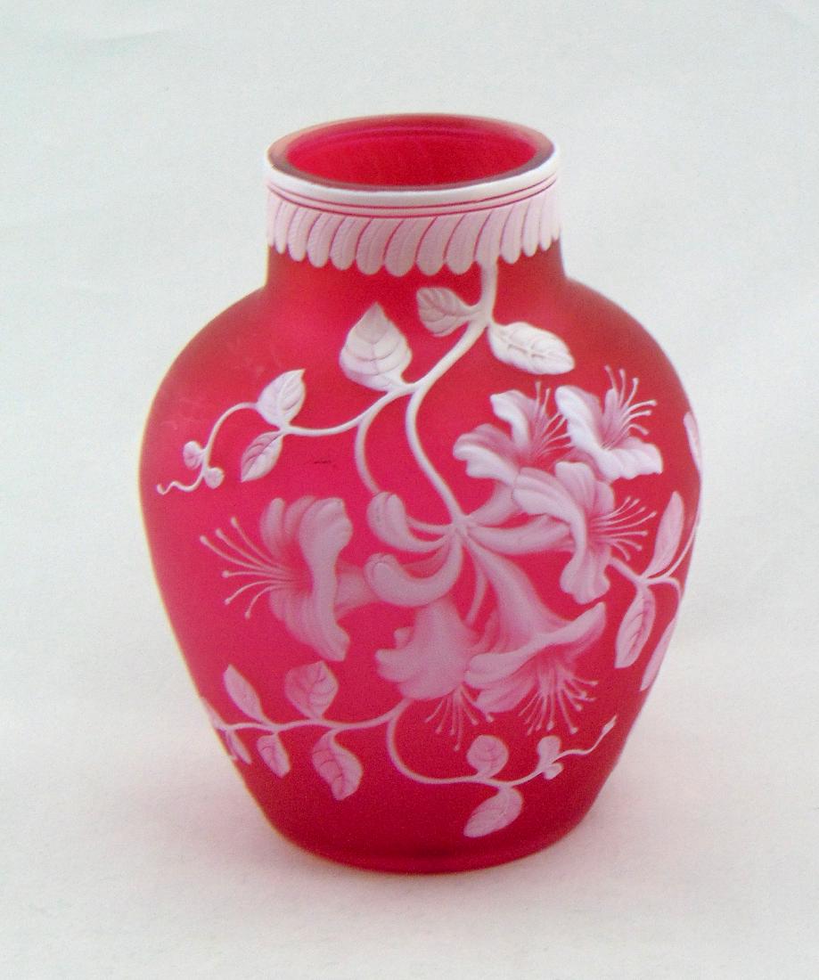 Webb Honeysuckle Cameo Glass Vase: Shouldered form in red glass decorated with a cascading random Honeysuckle vine, accented with a wave carved rim, 5" ht. Condition: good with no defects found