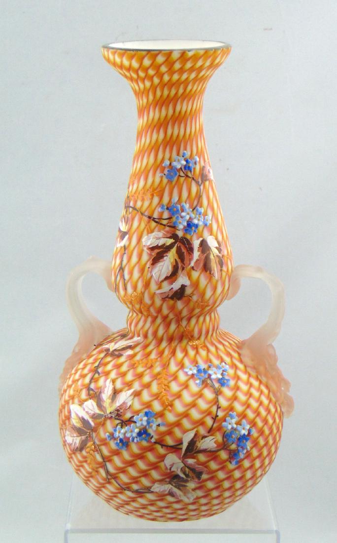 Stevens and Williams Glass Vase: Bulbous stick form with two applied camphor handles in a pink, amber and yellow zig zag pattern decorated with enameled branches of blue flowers, 11" ht. Condition: minor roughness to the handles one 