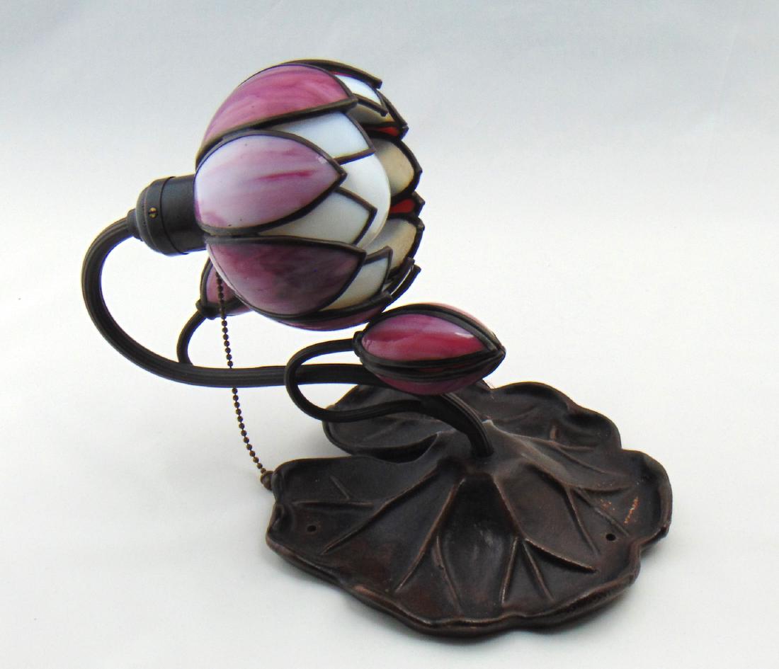 Handel Glass and metal wall sconce,: Two arm sconce with pink and white stain glass attached to a lily pad bronze fixture, signed Handel, 12 1/2" ht. Condition: good with no defects found.