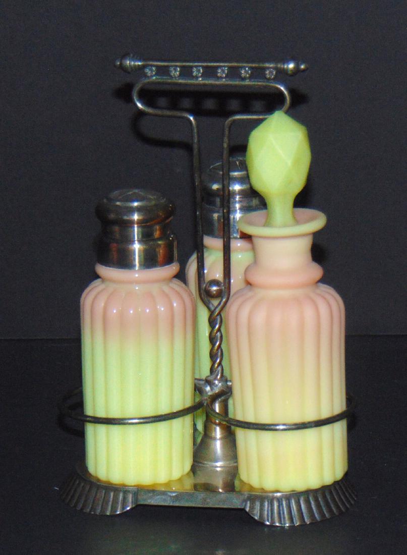 Burmese Condiment Set: Mt. Washington ribbed Burmese condiment set including together with a satin glass cruet, set in a Pairpoint silver plate caddy, 7" ht. Condition: good with no defects found.