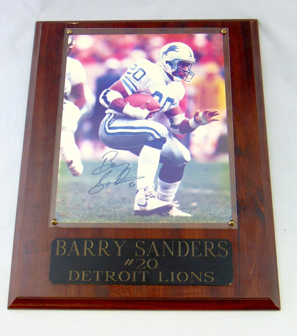 Signed Barry Sanders plaque: Wood framed picture of Barry Sanders with title plaque Barry Sanders #20 Detroit Lions, autographed by Barry. 8 by 10" picture overall 15" ht. Condition: good, with minor wear