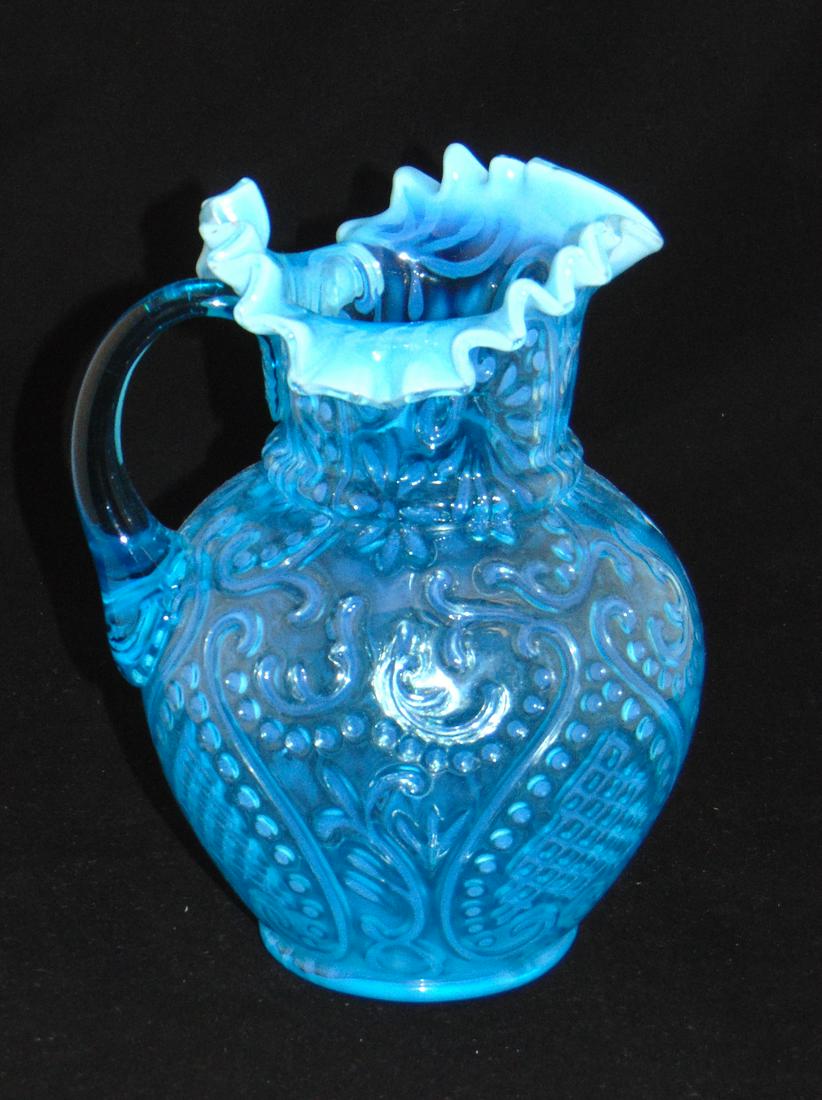 Beaumont Arabian Nights water pitcher: Ovoid form in blue opalescent glass decorated with the "Arabian Nights" dŽcor, 9" ht. NOTE: see Heacock "Opalescent Glass From A-Z page 170. Condition: good with no defects found.