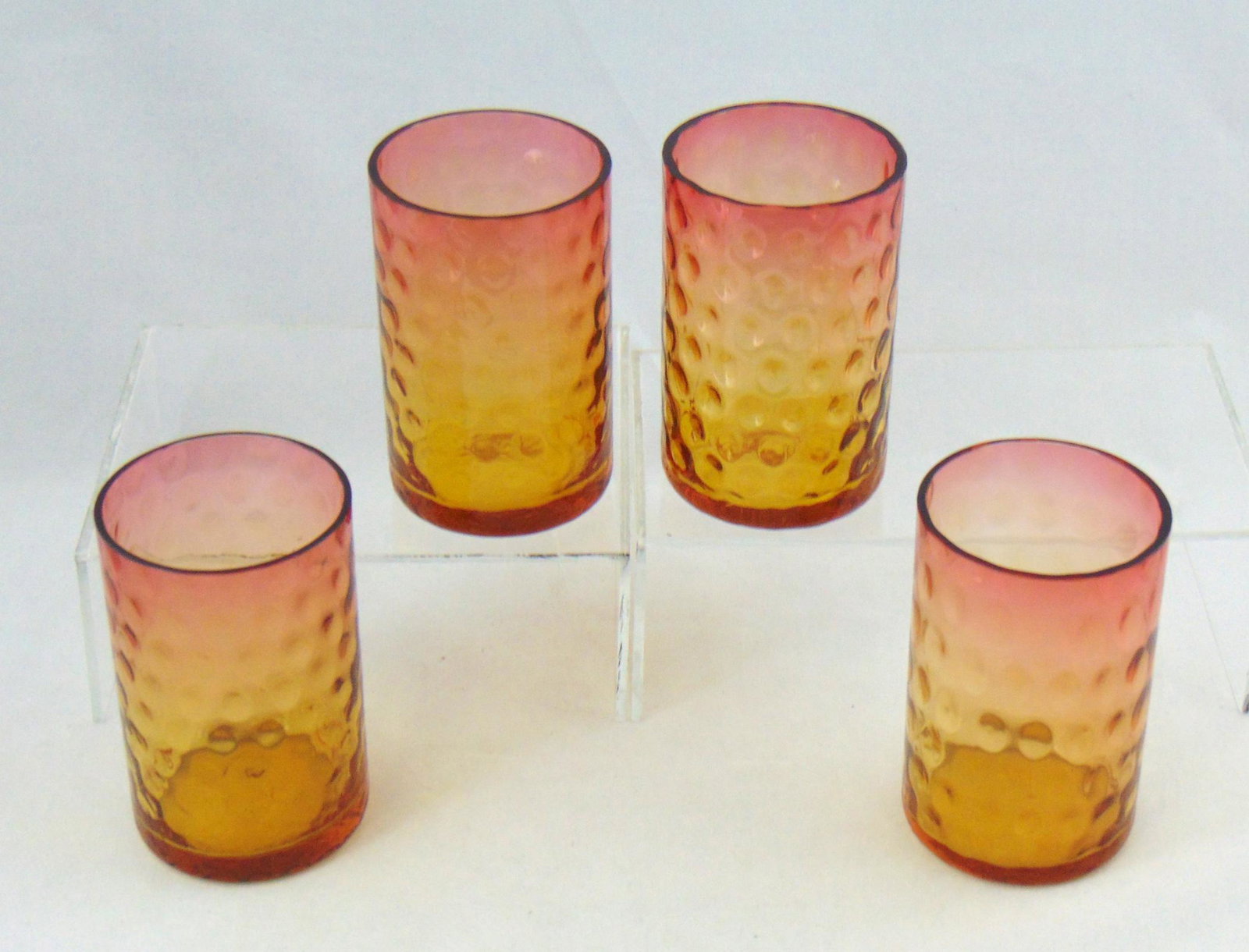 Four Libbey Amberina tumblers: Cylindrical form in amber to rose in the coin spot pattern, each signed Libbey, 4" ht. Condition: good with no defects found.
