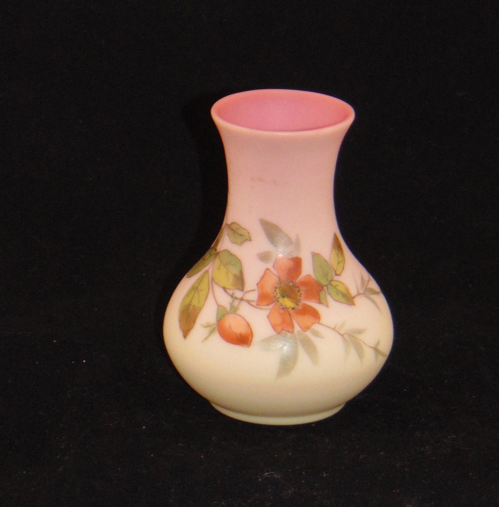 Webb Burmese bulbous vase: Bulbous form with a smoke stack rim decorated with a red Primrose on green leafy vines, 4" ht. Condition: good with no defects found.