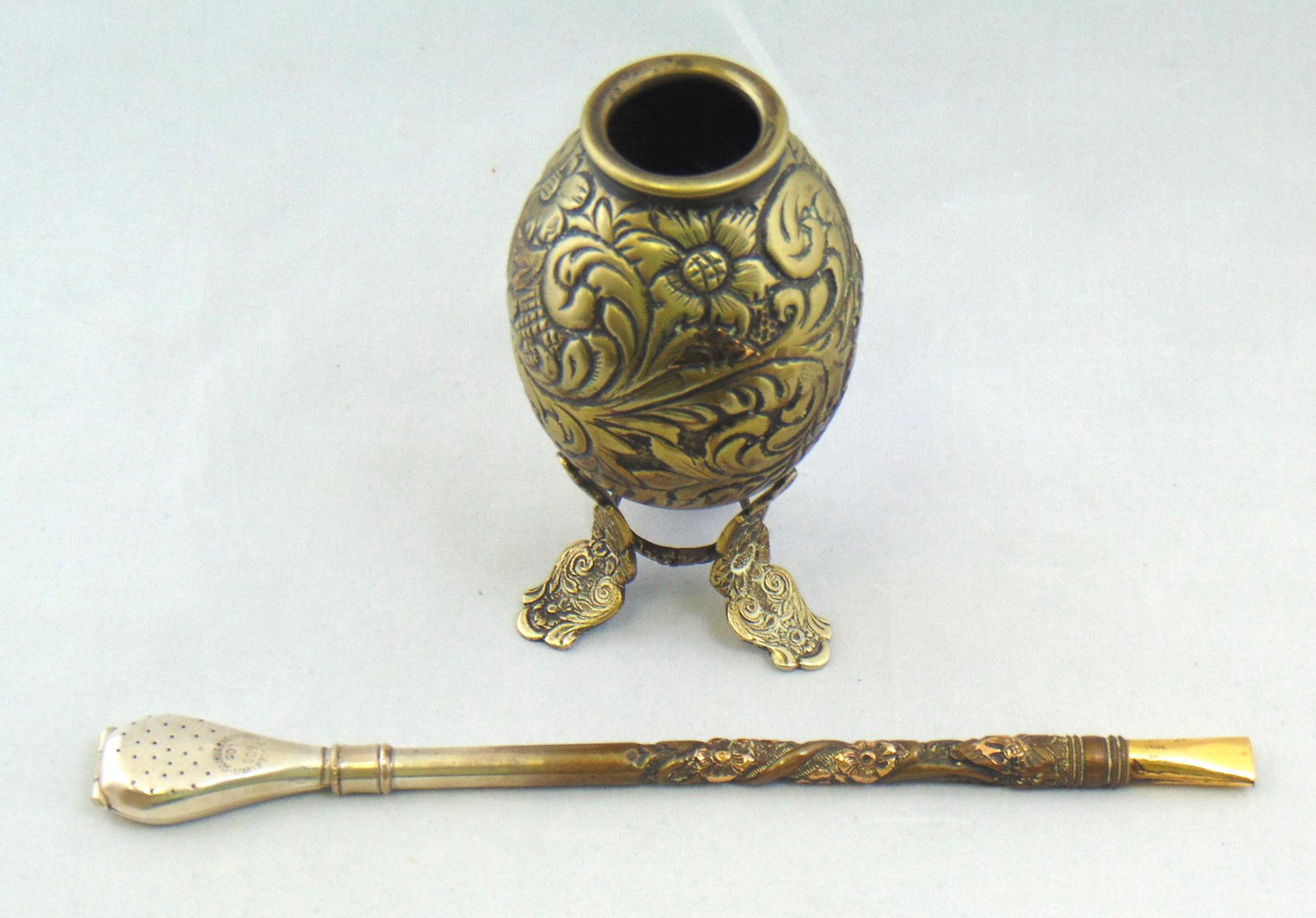 Argentina Silver Yerba Mate: Footed hand chased silver Yerba Mate embossed with a scrolling flower, marked Argentina 800 and 18K, stem 8" long. Condition: good with no defects found.