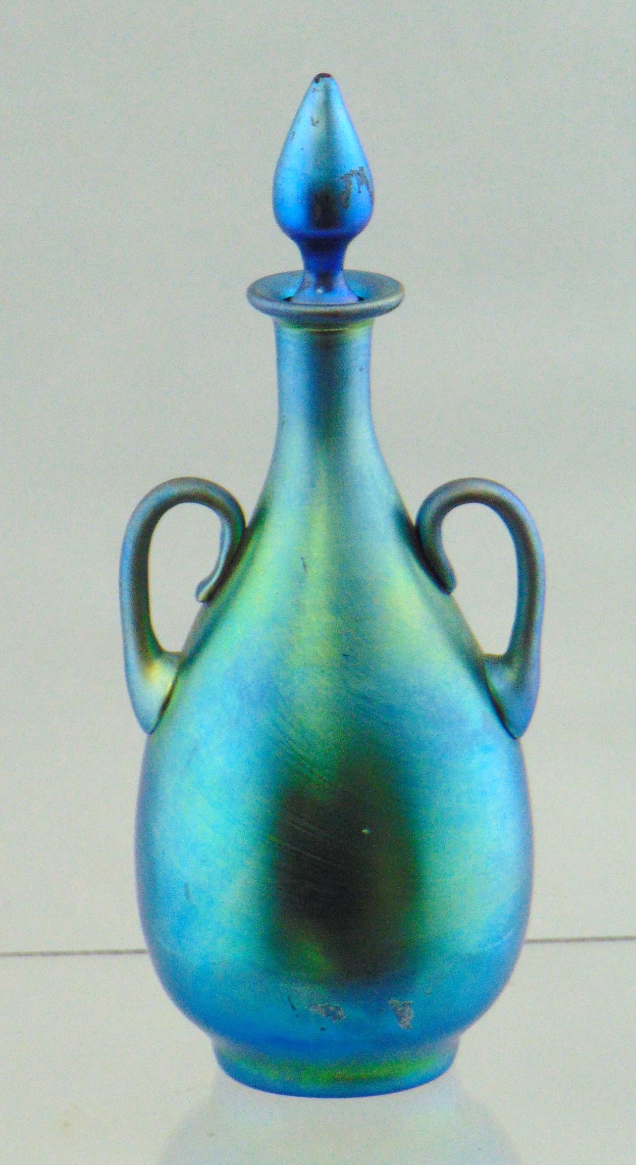 Steuben blue Aurene perfume: Footed bulbous form with two side handles, shape number 3048, signed Aurene 3048, 6 1/2" ht. Condition: very minor flake at the top of the stopper.