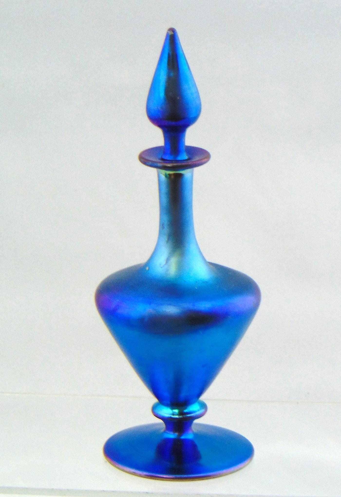 Steuben blue Aurene perfume: Footed urn form in Blue Aurene with a tear drop stopper, signed Aurene 3174, 7" ht. Condition: good with no defects found.