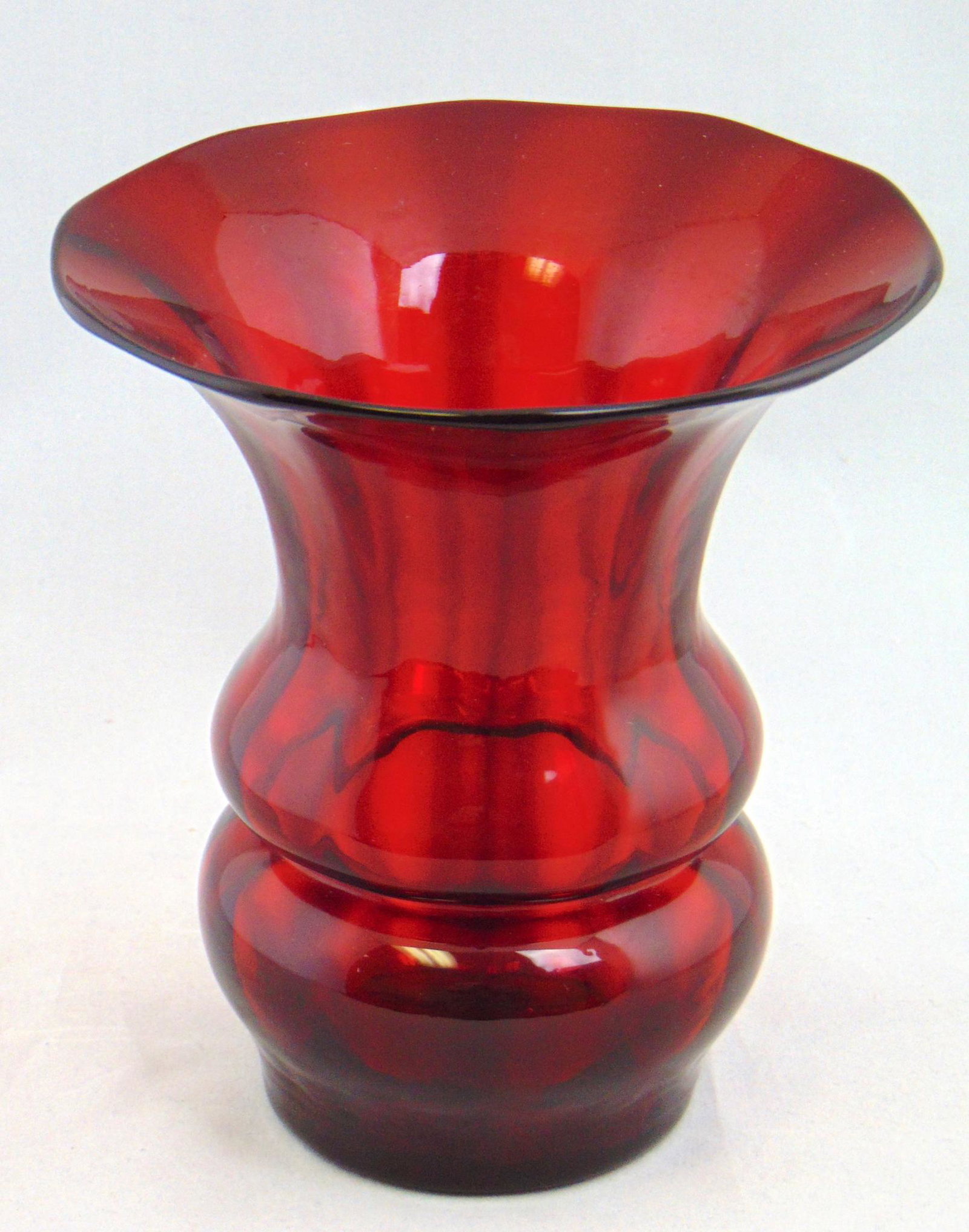 Steuben Selenium red glass vase: Optic ribbed shade form in deep red glass, 6" ht. Condition: good with no defects found.