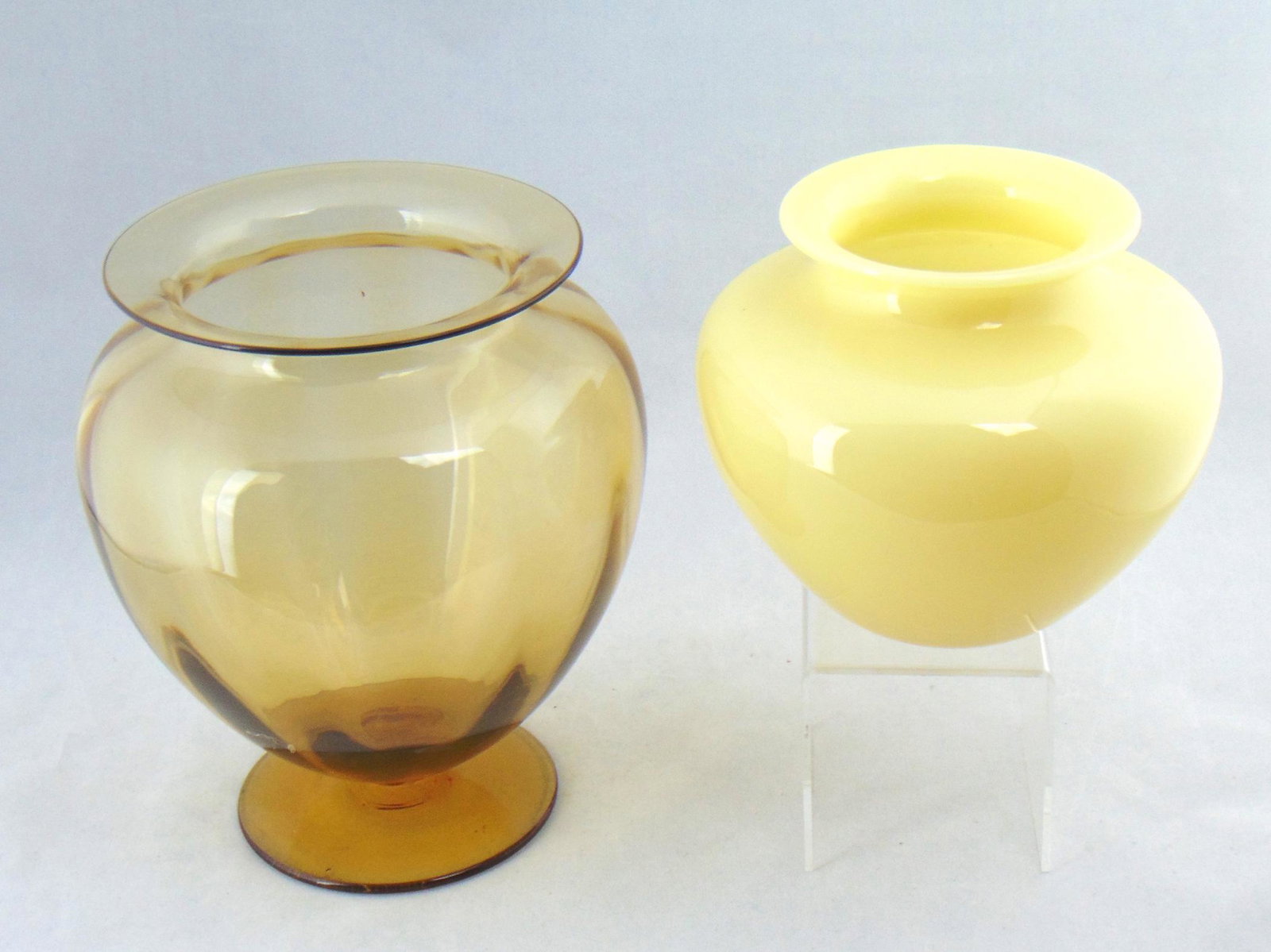 Two Steuben glass vases: Including a footed amber glass vase together with a classic form Ivory shouldered vase, amber 8" ht. Condition: good with no defects found.