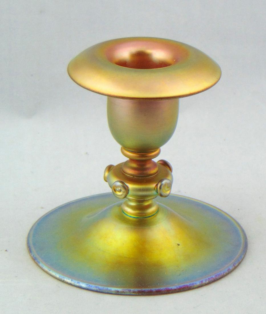 Steuben Gold Aurene glass candlestick: Low baluster form adorned with side prunts, signed Aurene 6384, 3 1/2" ht. Condition: good with no defects found.