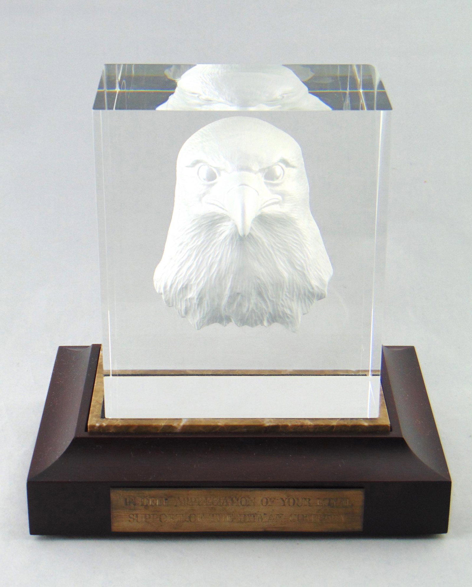 Steuben eagle glass cube: Rectangular form cube in clear glass decorated with a cut eagle set on a wood stand with appreciation plaque that reads "In deep appreciation of your loyal support of the Pitman Company," glass signed