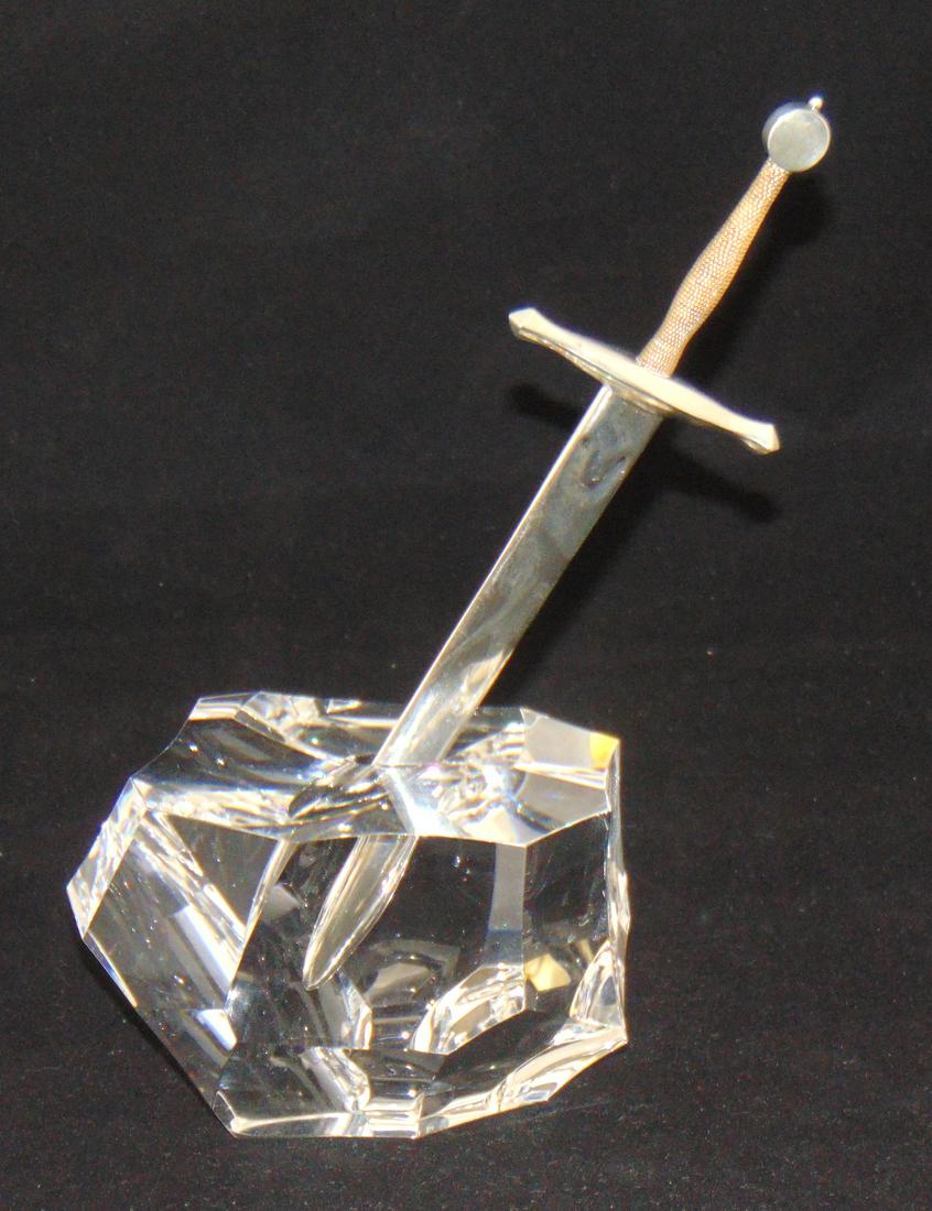 Steuben Excalibur with box,: Glass sculpture depicting the legendary sword in the stone, clear glass faceted stone carries a sterling and gold sword, together with the factory red leather box, glass marked Steuben, sword marked S