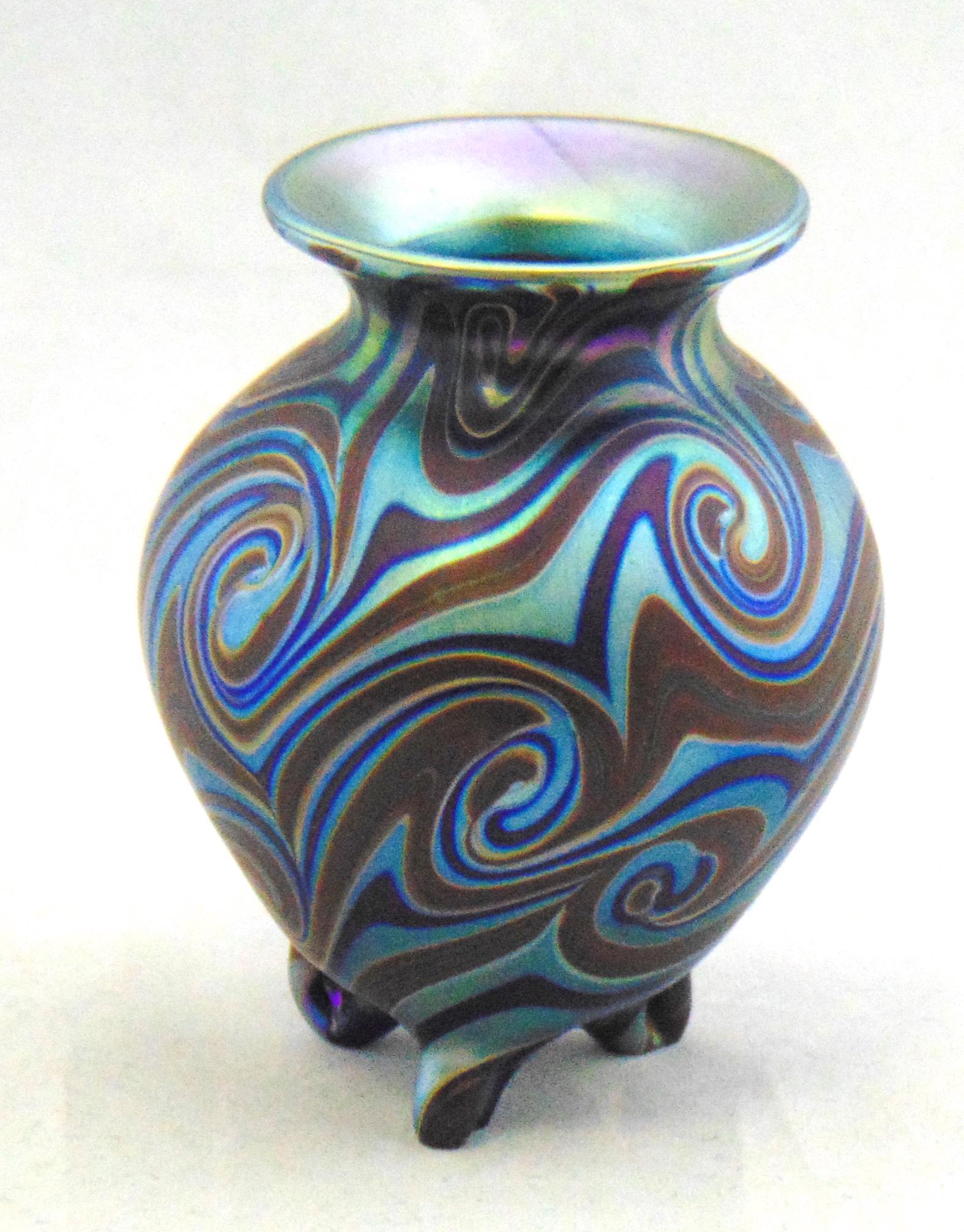 Early Steve Lundberg glass vase: Diminutive footed form decorated with a King Tut design in blue, cobalt, and caramel, signed LS SL 75, 3" ht. Condition: good with no defects found.