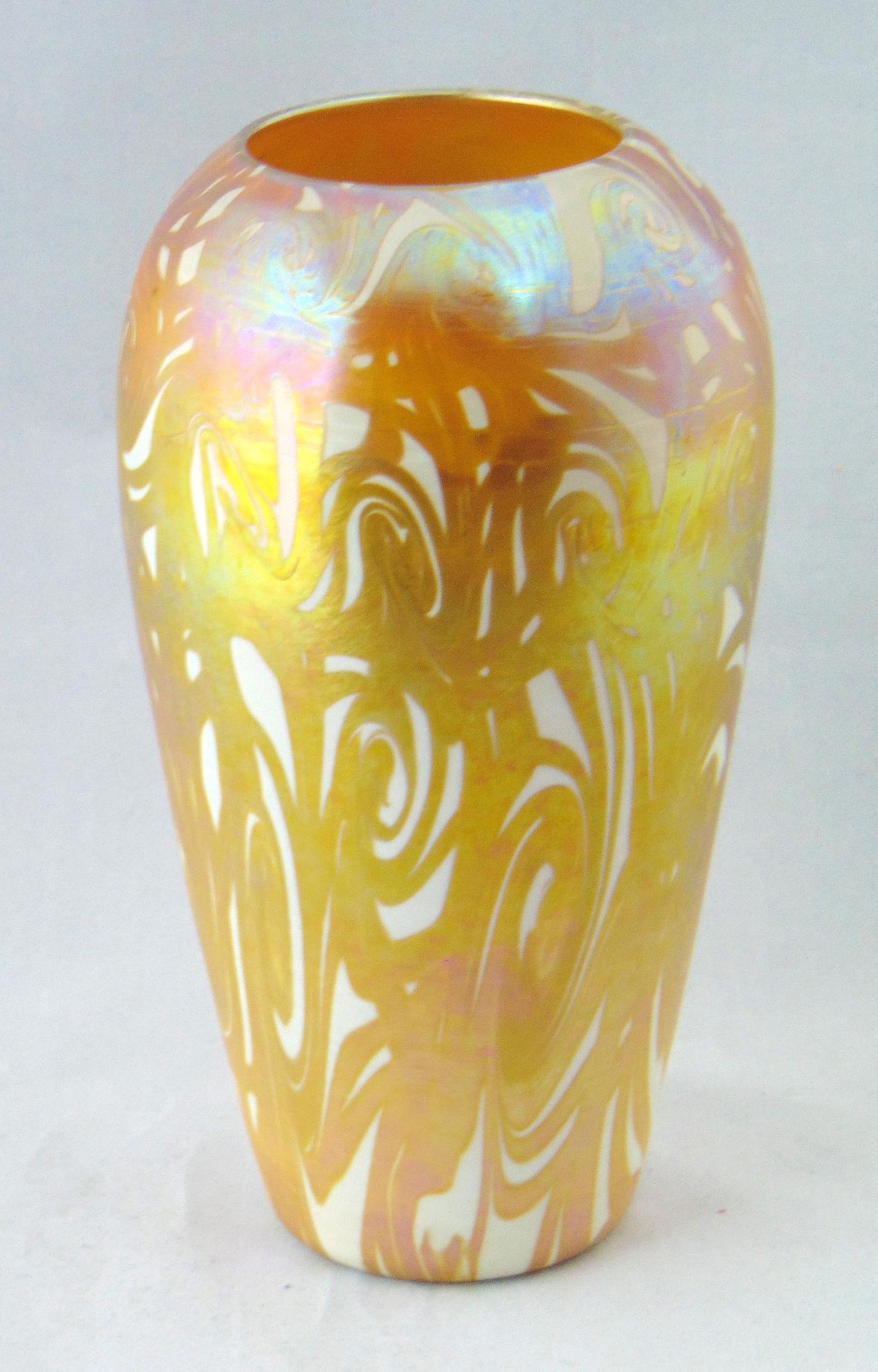 Quezal King Tut art glass vase: Cylindrical form in opal glass decorated with an iridescent gold King Tut design, signed Quezal, 9" ht. Condition: good with no defects found.