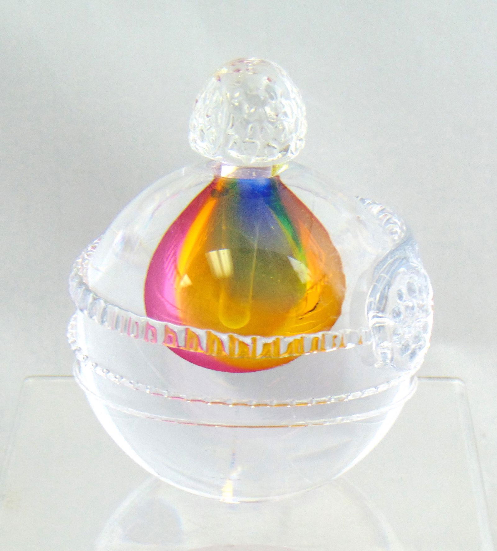 Leon Applebaum art glass perfume: Ovoid form with raspberry prunt and saw tooth appliquŽ in clear glass decorated with a central cavity of red, blue and yellow glass, signed Leon Applebaum, 4 1/4' ht. Condition: good with no defects