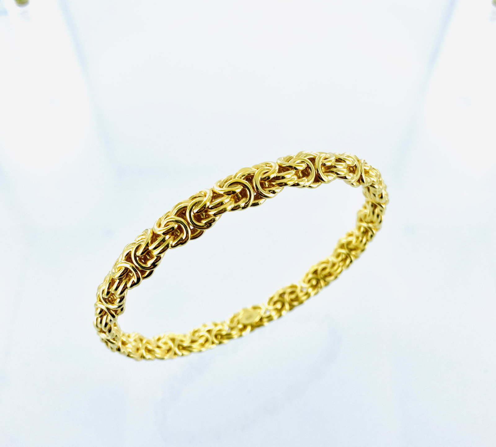 Yellow gold Byzantine bangle: 14K yellow gold Byzantine style resin filled bangle bracelet. The bracelet is extra large and measures approximately 5/16' in width and 2 3/4" in diameter. The actual gold weight is unknown as bracele