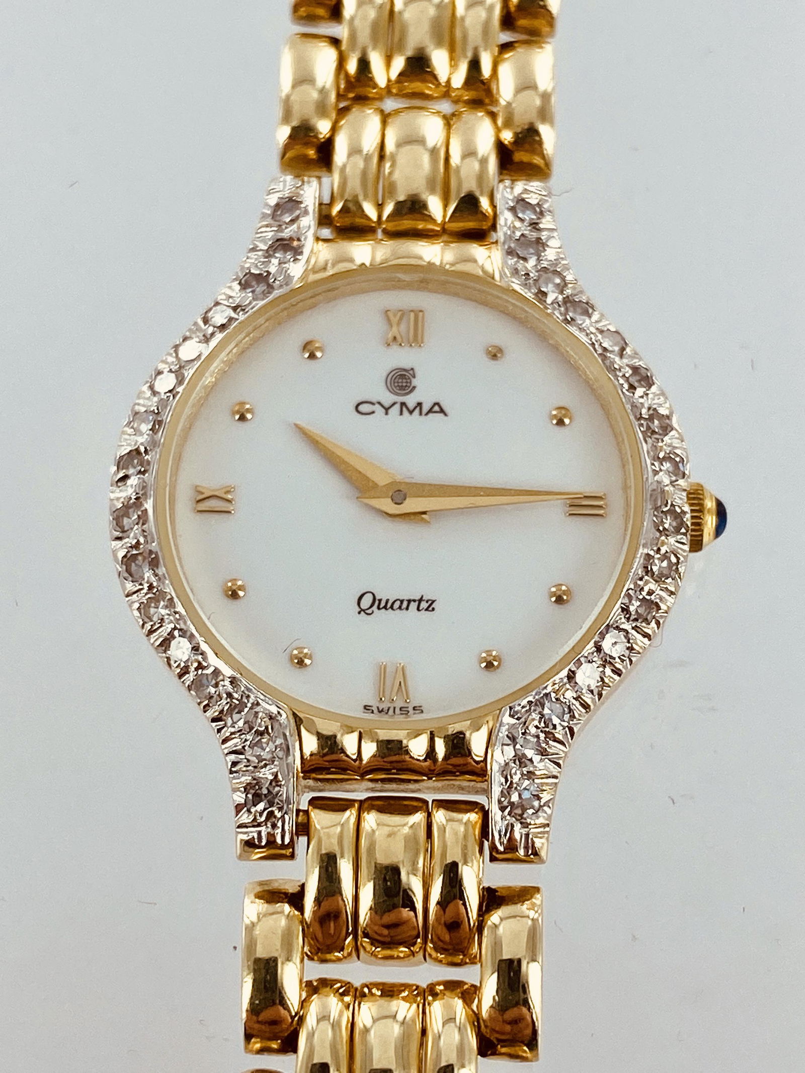 Yellow gold and diamond ladies Cyma quartz watch: Ladies 14K yellow gold and diamond Cyma quartz watch containing 32 single cut diamonds with an estimated total weight of 1/2 carat. The watch weighs 36 grams without movement. It is 7" in length with