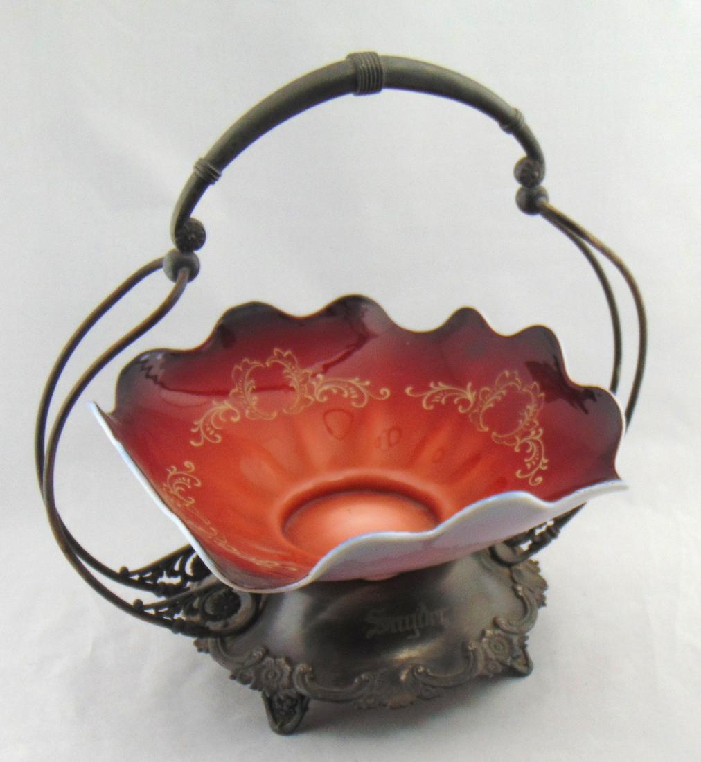 Webb Peachblow brides basket: Peachblow scalloped rim brides bowl set in an embossed metal basket, bowl with acid stamp Thomas Webb and Sons, 12" ht. by 12" wide. Condition: factory line on white layer bowl still rings.