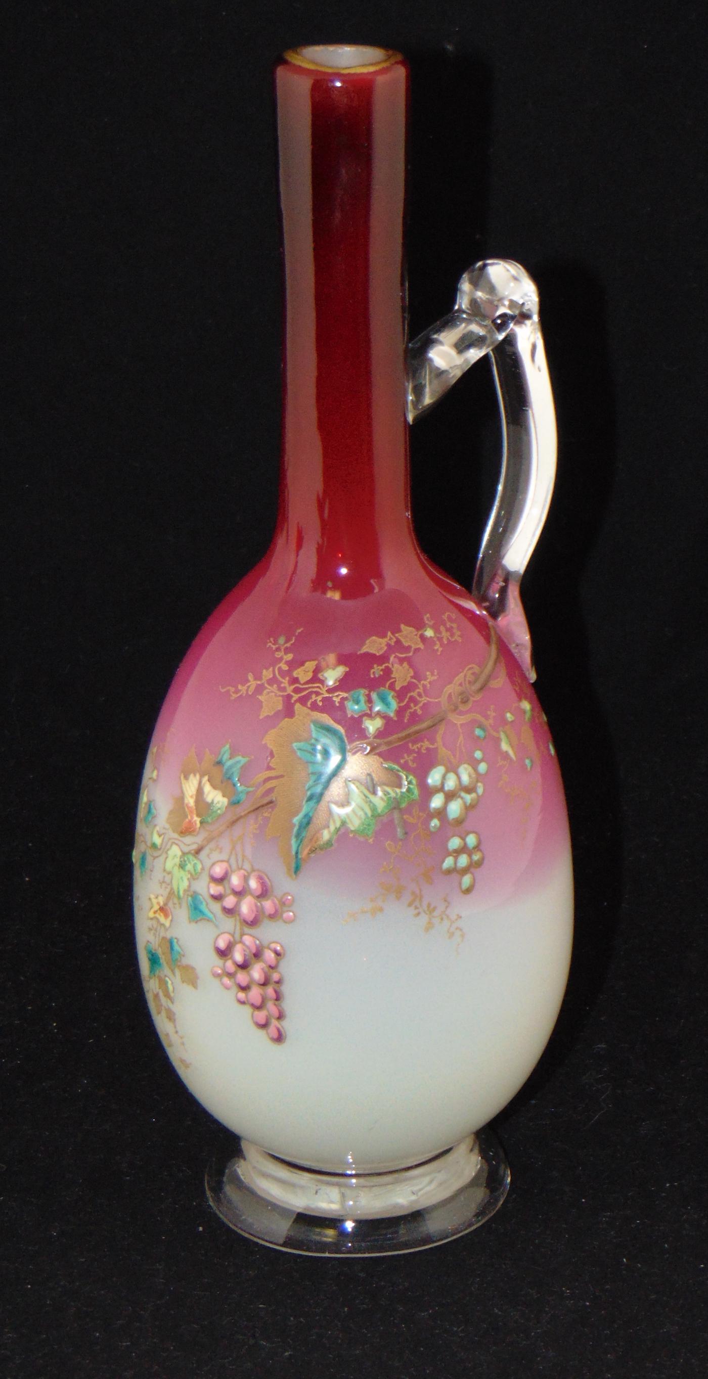 Webb Peachblow glass ewer,: Footed bottle form in white to rose with an applied clear handle decorated with 11" ht. Condition: good with no defects found