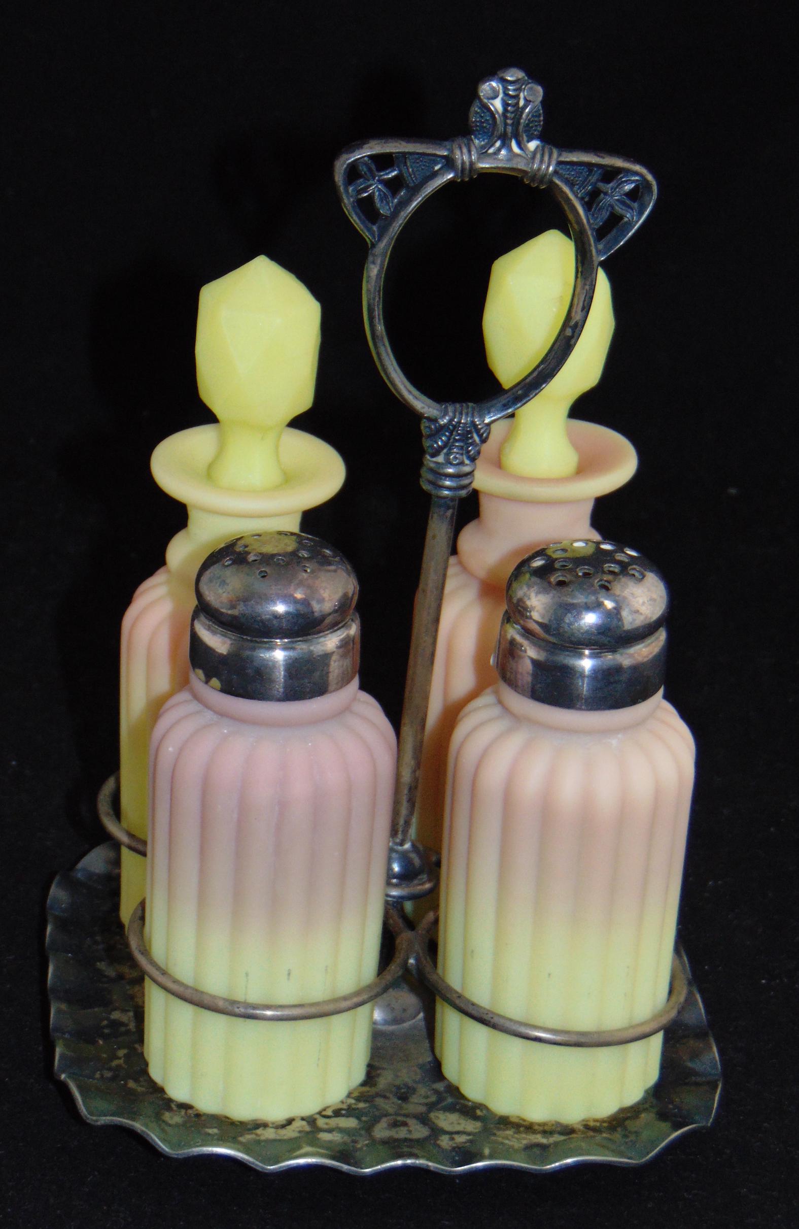 Mt. Washington Burmese condiment set: Burmese condiment set including two shakers and two vinegar bottles with faceted stoppers, set in a marked Pairpoint caddy, 7 1/2" ht. PROVENANCE: Earlys Auction to the Black collection. Condition: go