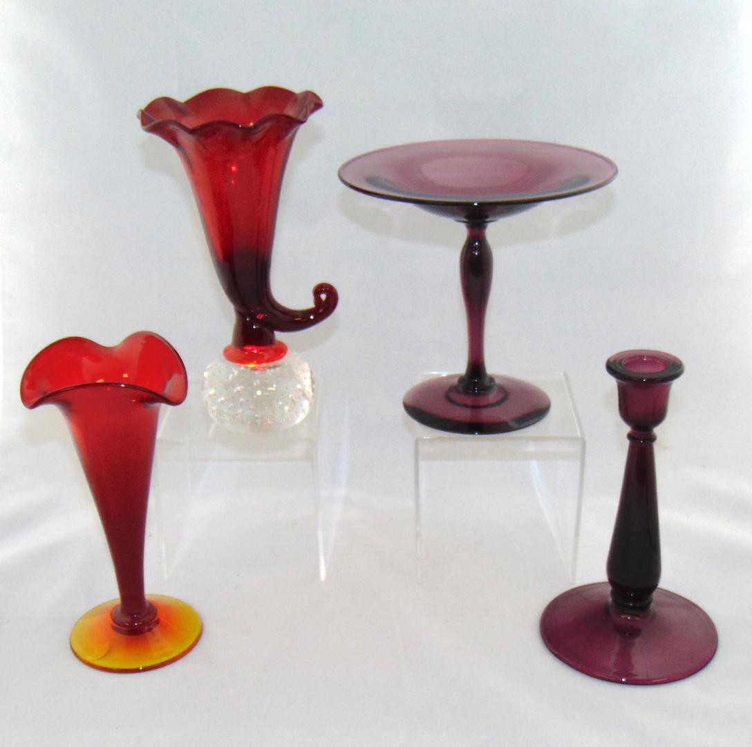 Pairpoint glass vase and more: Four piece grouping of glass, including a Pairpoint ruby cornucopia vase, a Pairpoint ruby trumpet and two purple glass items attributed to Pairpoint, tallest 7 1/2" ht. Condition: good with no defect