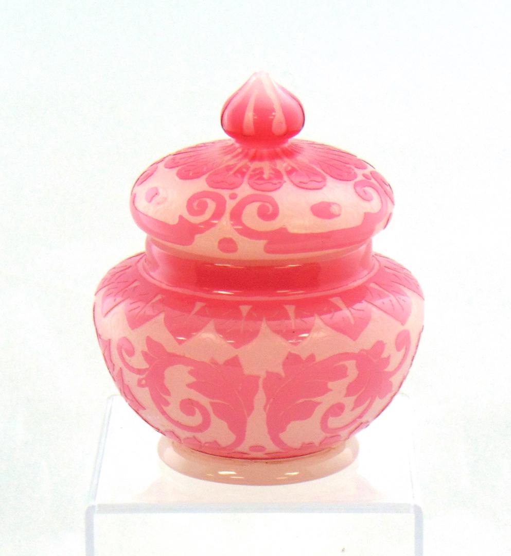 Steuben ACB covered jar: Ovoid alabaster jar with a Rosaline acid cut back in an oriental design fitted with a matching lid, 5" ht. LITERATURE: for exact example see "The Glass of Frederick Carder" by Gardner plate xxv. Condi